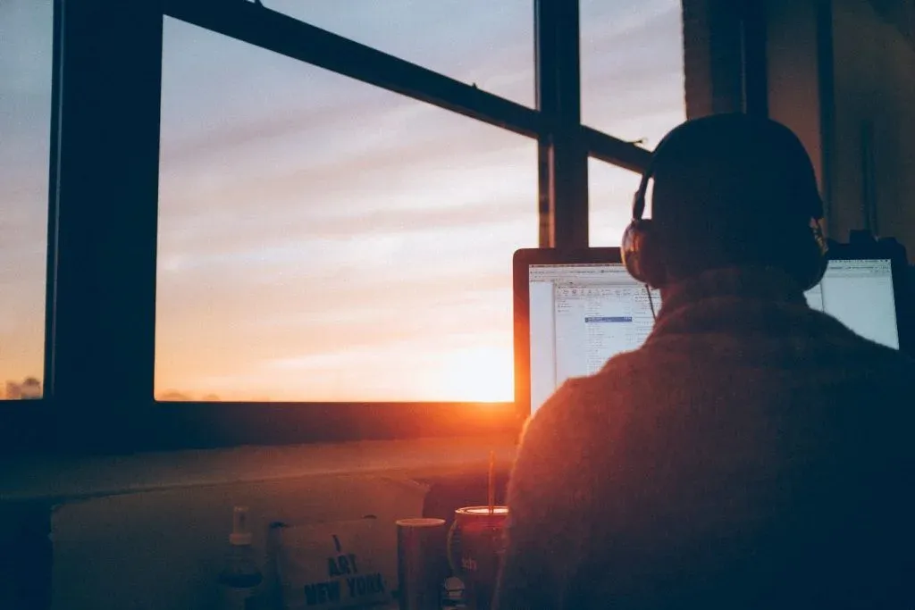 Man looking out of a window with his laptop, duplicate records in sql