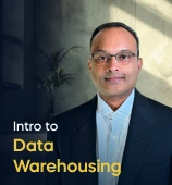 The Introduction to Data Warehousing course creator stands in a modern office setting with the text 'Introduction to Data Warehousing' on the left side of the image.