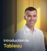 The Introduction to Tableau course creator stands in a modern office setting with the text 'Introduction to Tableau' on the left side of the image.