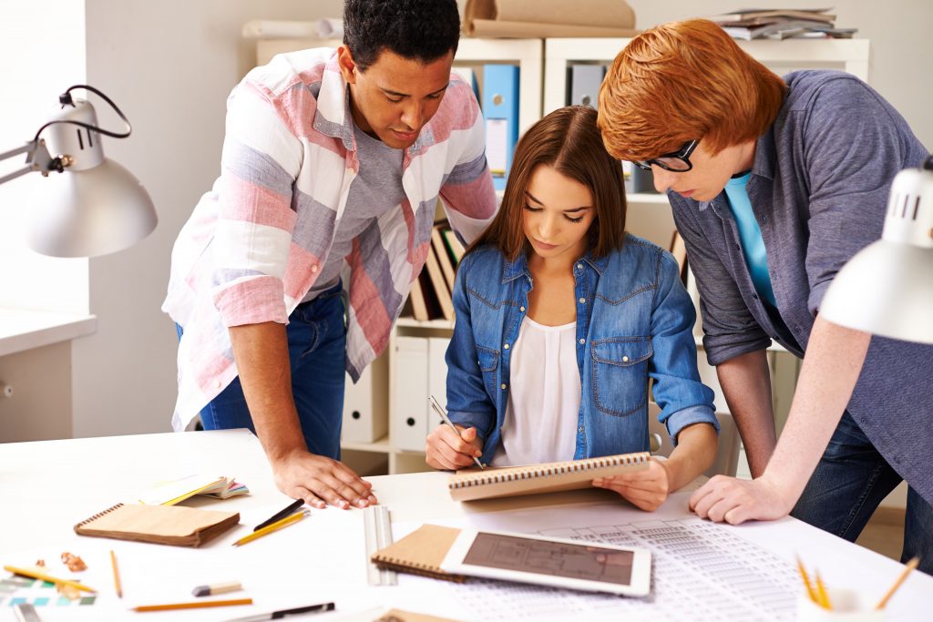 2 males and one female looking at stats on a table